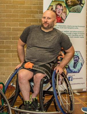 Wheelchair basketball banner -trainer Pete Bull with two players